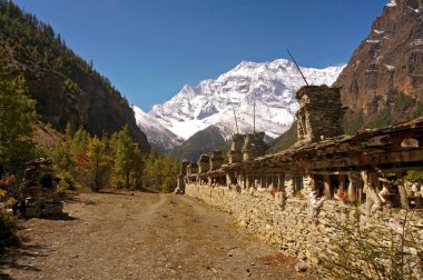 Antik Mani duvarında Avalokiteshvara 'nın Budist mantrasıyla yazılmış çakıl taşları ile Annapurna II tepesinin zeminine karşı, Ghyaru, Annapurna Pisti, Büyük Himalayalar, Nepal