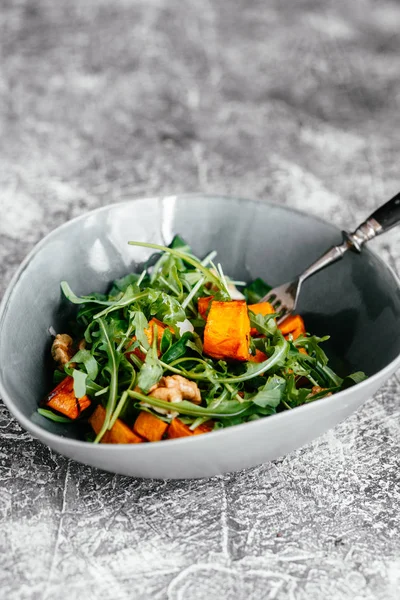 Pişmiş balkabağı vejetaryen salatası, roka ve kuruyemiş.