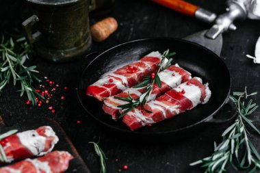 Izgara için baharatlı domuz pastırmalı rulo et.