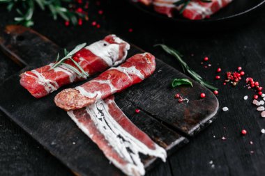 Izgara için baharatlı domuz pastırmalı rulo et.