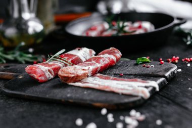 Izgara için baharatlı domuz pastırmalı rulo et.