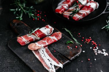 Izgara için baharatlı domuz pastırmalı rulo et.