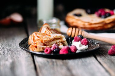 Böğürtlenli bir tabakta krep. Kahvaltıda. Maslenitsa