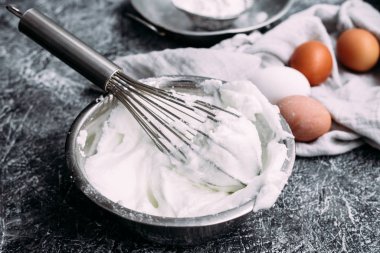 Kalın bir köpüğe çırpılmış yumurta beyazı. Beyaz çırpılmış yumurta tabağı, çırpılmış çırpılmış çırpılmış, kremalı