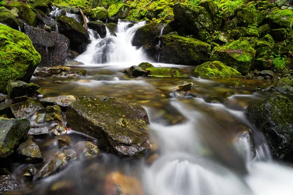 Flusso a cascata su rocce con una cascata — Foto Stock