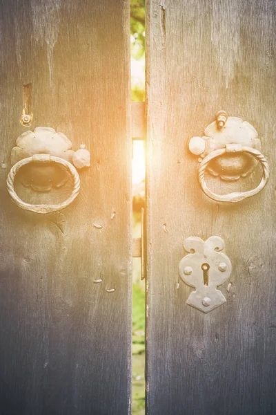 Two old iron ring handles on a door standing ajar — Stock Photo, Image
