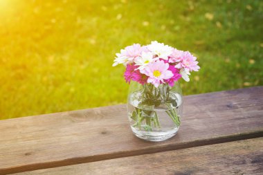Cam vazoda renkli pembe yaz çiçek