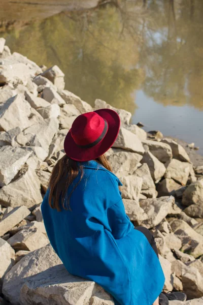 Dívka v modrém kabátě na kameny — Stock fotografie