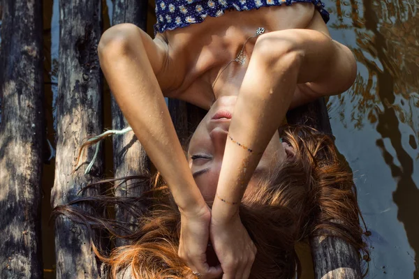 Jolie fille sur un pont en bois en été — Photo