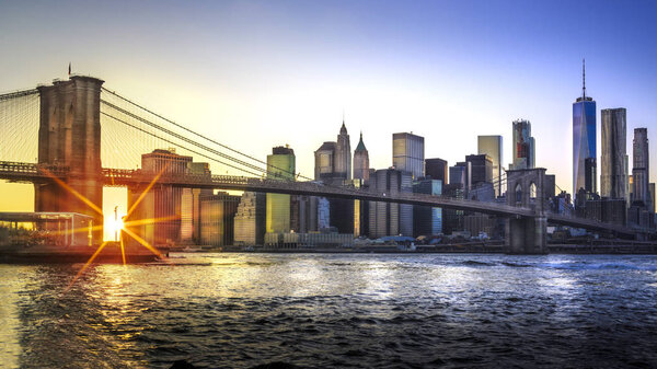 A magnificent view of the lower Manhattan and Brooklyn Bridge with sunset