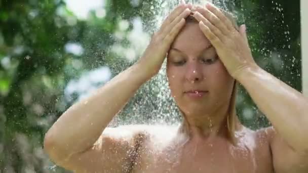 Femme blonde sexy prenant une douche en plein air — Video