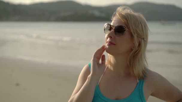 在海滩戴着墨镜的年轻女人 — 图库视频影像