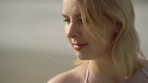 Jonge blonde vrouw in bikini op het strand het aanraken van haar lichaam — Stockvideo