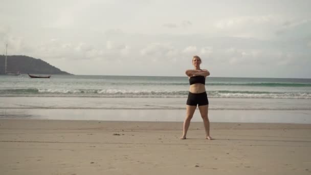 Junge blonde Frau macht Sport am Strand — Stockvideo