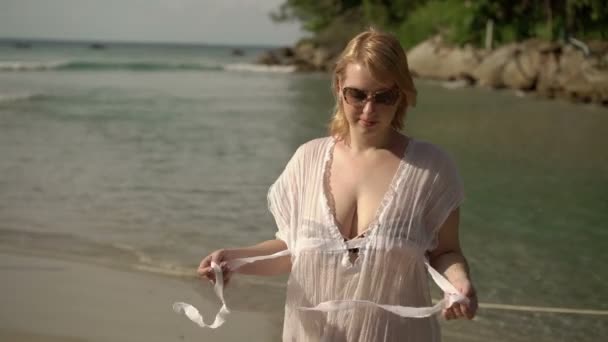 Młoda kobieta sexy rozbieranie na plaży — Wideo stockowe