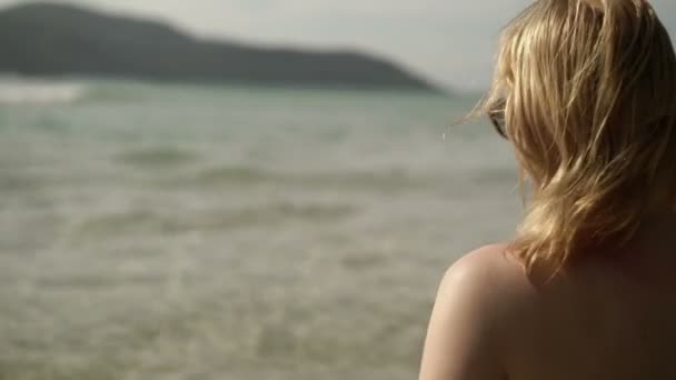 Молодая сексуальная женщина загорает в море — стоковое видео