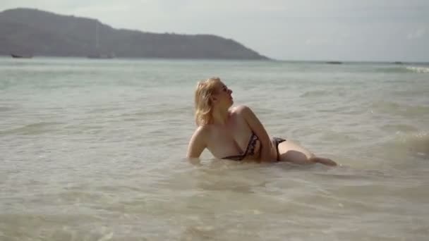 Mujer sexy joven tomando el sol en el mar — Vídeo de stock