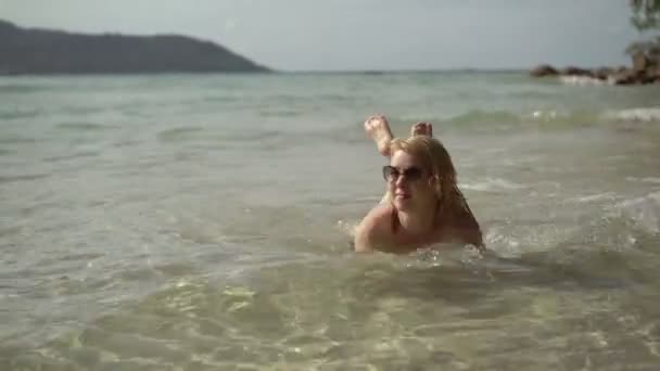 Молодая сексуальная женщина загорает в море — стоковое видео