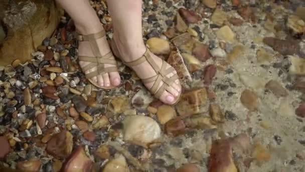 Γυναίκα που διαμένουν σε νερό στα παπούτσια σε μια παραλία — Αρχείο Βίντεο