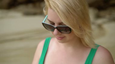 Sahilde kalıyor ve cep telefonuna mesaj yazma kadın