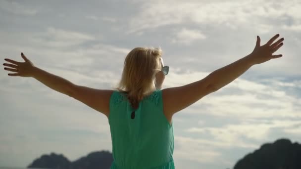 Mujer caminando sola en la playa salvaje y levantando las manos — Vídeo de stock