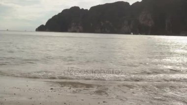 Yalnız mavi elbiseli sahilde yürüyen kadın