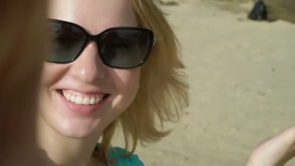 Woman staying on a beach and taking selfie — Stock Video