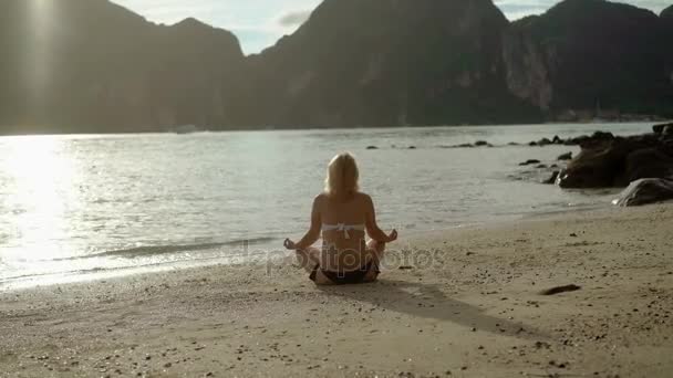 Młoda kobieta na plaży praktyki jogi w bikini — Wideo stockowe