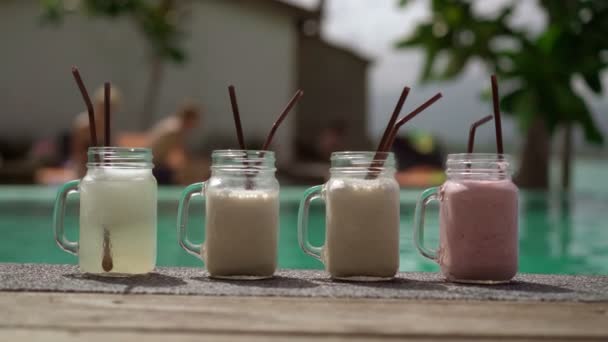 Vrouw hand nemen cocktail bij zwembad — Stockvideo