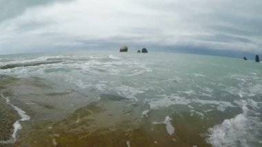 Dalgalar bir kayalık plaj