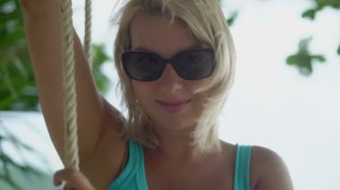 Genç kadın bir plajda salıncak üzerinde