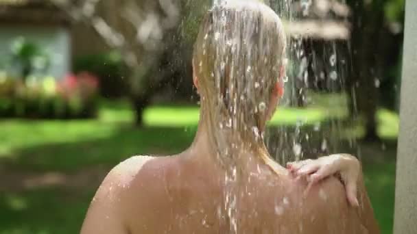 Femme blonde sexy prenant une douche en plein air — Video