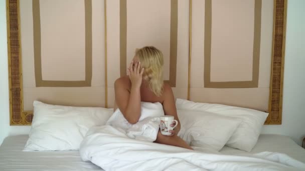Fiatal nő az ágyban csésze — Stock videók