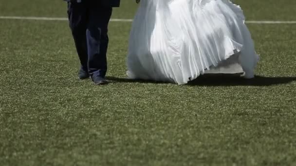 Boda pareja caminando en campo de fútbol — Vídeos de Stock