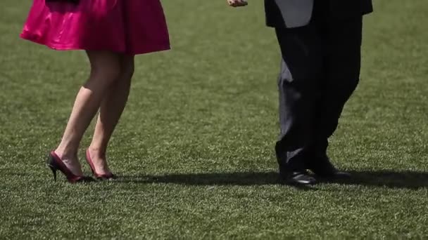 Мужчина и женщина танцуют на траве — стоковое видео