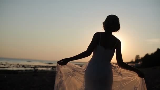 Braut spaziert am Abendstrand — Stockvideo