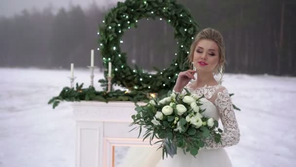 Giovane donna in abito bianco vicino decorazione camino sul lago congelato — Video Stock