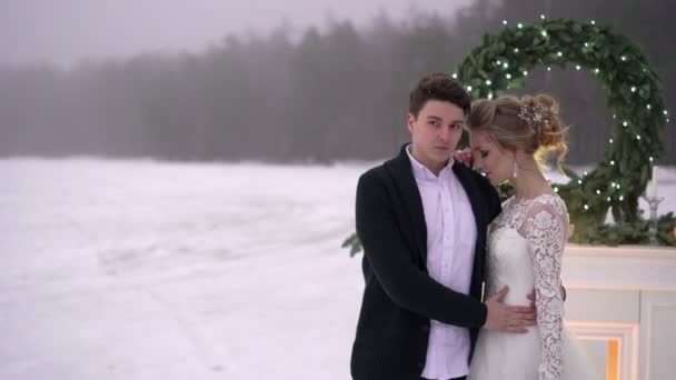 Hochzeitspaar bei Kamindekoration auf zugefrorenem See — Stockvideo