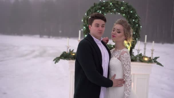 Wedding couple near fireplace decoration on frozen lake — Stock Video