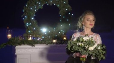 Şömine dekorasyonu donmuş göl üzerinde yakınındaki beyaz elbiseli genç kadın