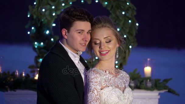 Wedding couple near fireplace decoration on frozen lake — Stock Video