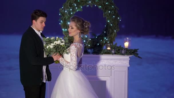 Wedding couple near fireplace decoration on frozen lake — Stock Video