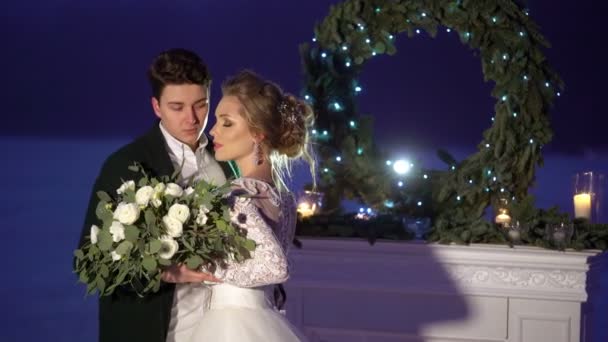 Bruidspaar in de buurt van open haard decoratie op bevroren meer — Stockvideo