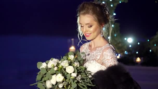 Şömine dekorasyonu donmuş göl üzerinde yakınındaki beyaz elbiseli genç kadın — Stok video
