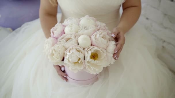 Linda mujer rubia joven en vestido de novia con flores ramo posando en el estudio — Vídeo de stock
