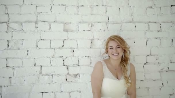 Süße junge blonde Frau im Hochzeitskleid posiert im Studio — Stockvideo