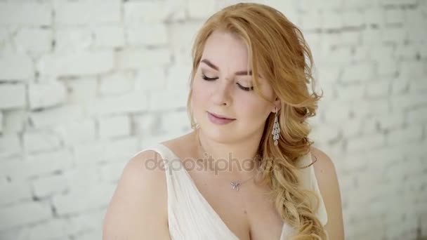 Молодая женщина в свадебном платье с тарелкой конфет — стоковое видео