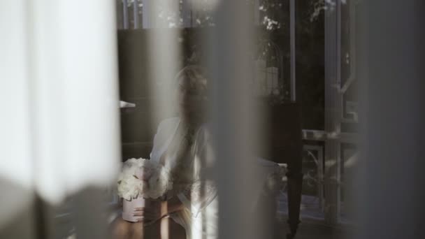 Carino giovane donna bionda in lingerie seduta con mazzo di fiori sparato attraverso la finestra — Video Stock