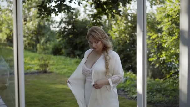 Linda mujer rubia joven en lencería con albornoz — Vídeos de Stock