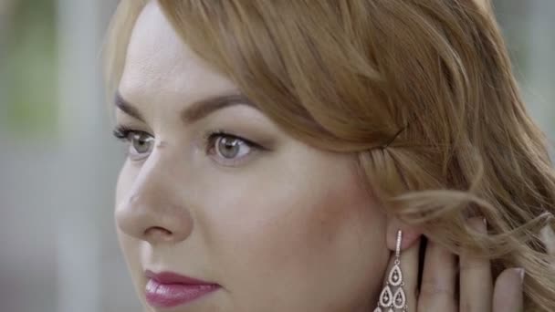 Cute young blonde woman in lingerie wearing earrings — Stock Video